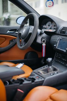 the interior of a car with an orange leather steering wheel cover and dash sticker