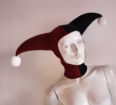 a white mannequin head wearing a red and black hat