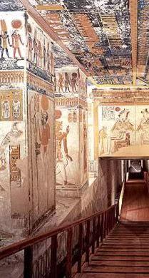 an egyptian style room with paintings on the walls and wooden stairs leading up to it