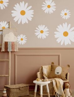 a child's room with pink walls and white daisies on the wall, along with a teddy bear