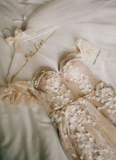 the wedding dress is laying on top of the bed with its name written on it