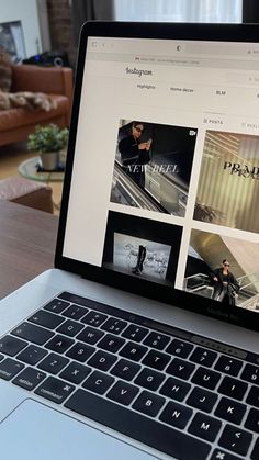 an open laptop computer sitting on top of a wooden table in front of a couch