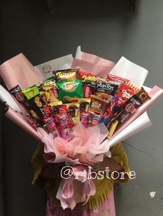 a woman holding a bouquet of candy and candies