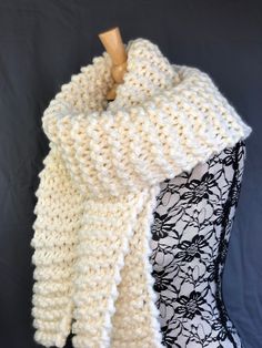 a white knitted scarf on top of a mannequin