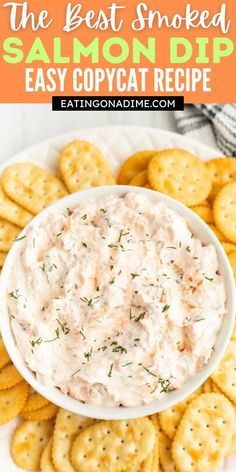 the best smoked salmon dip in a bowl with crackers around it and text overlay that reads, the best smoked salmon dip easy copycat recipe