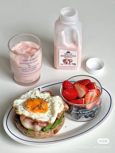 a plate with a sandwich, strawberries and yogurt next to a glass of water