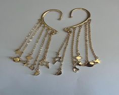 Ear wrap cuff with moons and stars  and saturns in silver or gold. one size fits all.  Can be worn as a pair or a single. Adjustable Gold Ear Cuff For Festivals, Ear Wrap Cuff, Moons And Stars, Golden Wings, Solana Beach, Wrap Earrings, Ear Cuffs, Cuff Earrings, One Size Fits All