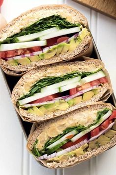 there are four sandwiches with different toppings on the bread and one is cut in half