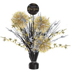 a black vase filled with yellow and silver flowers next to a happy new year sign