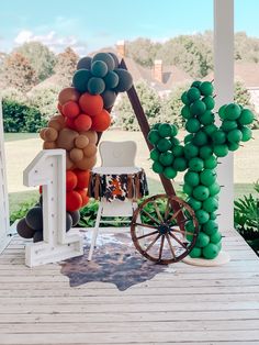 an outdoor area with balloons, chairs and a wagon on the ground in front of a house