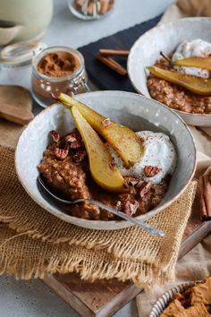 two bowls filled with oatmeal topped with sliced pears