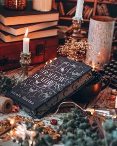 a book sitting on top of a table next to candles