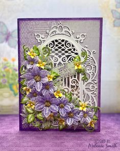 a close up of a card with purple flowers on the front and green leaves on the back