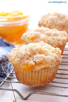 three peach cobbler muffins on a cooling rack