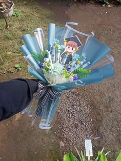 a bouquet of flowers is being held up by someone's hand on the ground