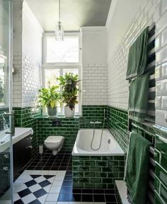 a bathroom with green and white tiles on the walls