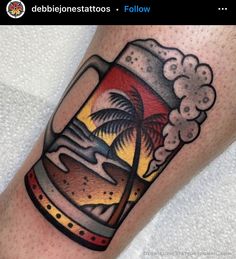 a man's arm with a beer and palm tree tattoo on the left leg