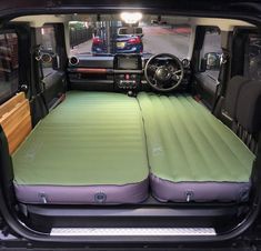 the interior of a vehicle with two mattresses in the back