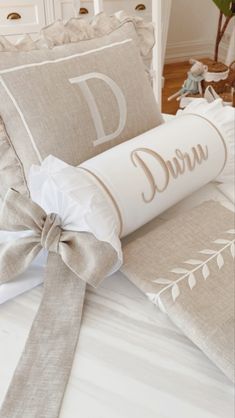 a bed with two decorative pillows and a bow on the headboard in front of it