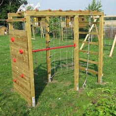 a wooden play structure with climbing ropes and ladders