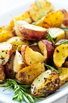 roasted potatoes with herbs and seasoning on a white plate