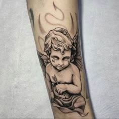 a small tattoo on the arm of a little angel