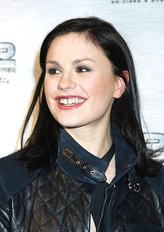 a woman wearing a black leather jacket and smiling