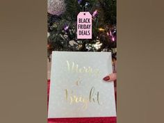 a christmas tree is decorated with pink and gold ornaments, while a sign reads merry and bright hangs from the top