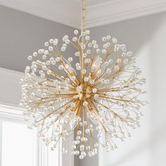 a chandelier hanging from the ceiling in a room with white walls and windows