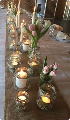 a long table with candles and vases filled with flowers