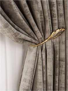 a curtain with a gold feather on it