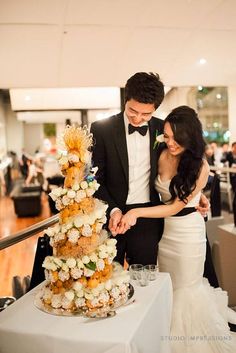 a newly married couple cutting their wedding cake