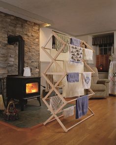 towels are hanging on a rack in front of an open fire place with a wood stove