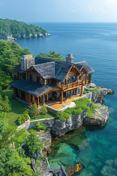 this is an aerial view of a house on the water's edge, surrounded by trees and rocks