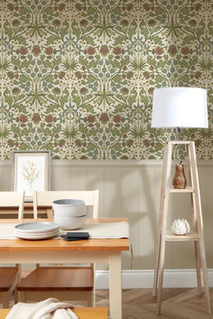 a dining room with a table and chairs in front of a wallpapered wall