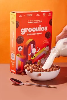 cereal is being poured into a bowl with a milk bottle next to it and an orange background