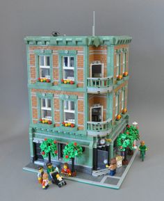 a building made out of legos with people standing outside