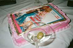 there is a cake with a magazine on it and a martini glass in front of it