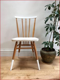 a wooden chair next to a potted plant