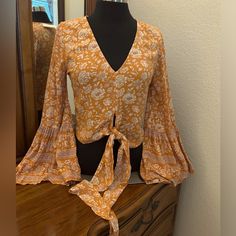 American Eagle Boho Peasant Top With Beautiful Flared Bell Sleeves. V Neckline And Ties At The Waist Line. Ptp Is 18 Inches And Length Is 18 Inches. As You Can Tell By The Ptp It Can Easily Fit A Small Maybe Even A Medium. Color Is Orange And Cream. Brand New With Tags. Fabric Is 100% Viscose. Very Soft And Light. Absolutely Gorgeous. Item 074. Orange Bohemian V-neck Top, Casual V-neck Peasant Top For Fall, Fall Peasant V-neck Top, Fitted Long Sleeve Peasant Top For Festival, Summer Peasant Tops With V-neck, Spring Festival V-neck Peasant Top, Trendy V-neck Top For Festivals, Bohemian V-neck Rayon Peasant Top, Orange Long Sleeve Top With Boho Print