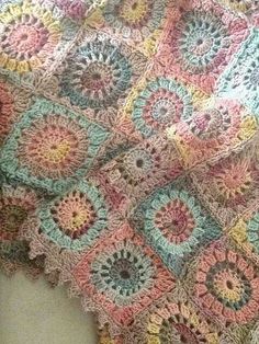 a crocheted blanket is laying on the floor