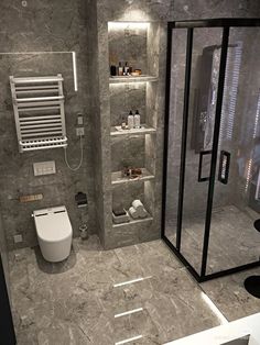 a bathroom with grey marble walls and flooring, including a walk - in shower