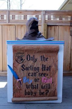 an image of a man sitting on top of a box with a sign that reads, only the sorting hat can see what will baby be?