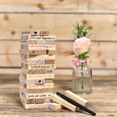 a stack of wooden blocks sitting on top of a table next to a vase filled with flowers