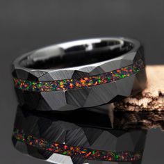 two rings with black and green opal inlays on top of each other