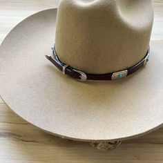 Genuine brown leather hat band decorated with silver metal conchos and turquoise colored stone. This hat band is adjustable with an attractive side buckle. Made in the USA Genuine Leather Adjustable sizing *This product is for 1 single hat band. Hat not included. Adjustable Western Hat With Concho, Western Adjustable Concho Hat, Southwestern Adjustable Concho Hat, Adjustable Southwestern Concho Hat, Western Concho Hat Band For Festival, Adjustable Western Hat Band With Concho, Southwestern Adjustable Hat Band With Concho, Adjustable Concho Hats For Western-themed Events, Adjustable Southwestern Hat Band With Concho