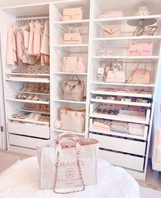 a closet filled with lots of pink purses and handbags on top of white shelves