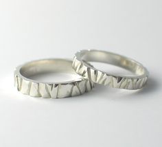 two silver rings sitting next to each other