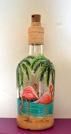 a bottle with two flamingos painted on it