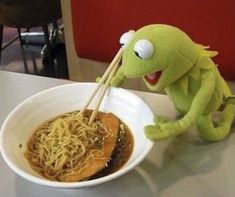 kermik the frog eating spaghetti in a bowl